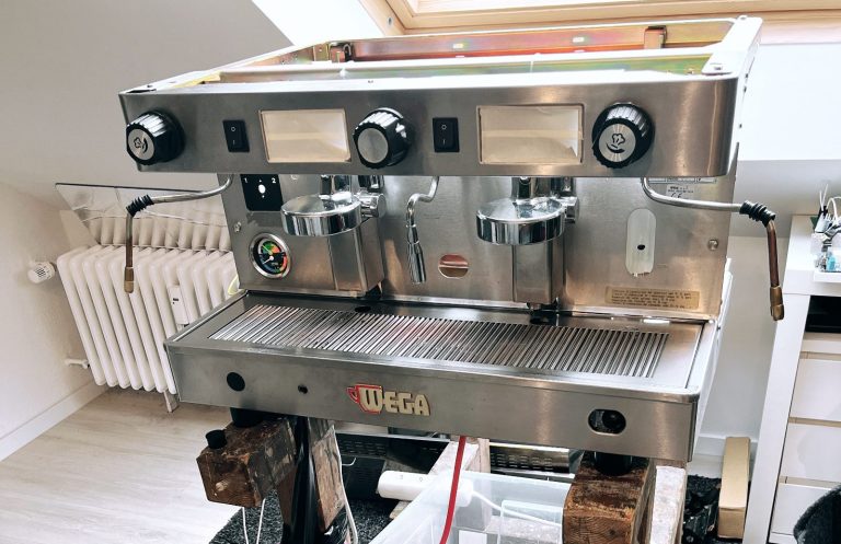 Geöffnete Espressomaschine auf einem Versuchsstand mit angeschlossener Wasserführung